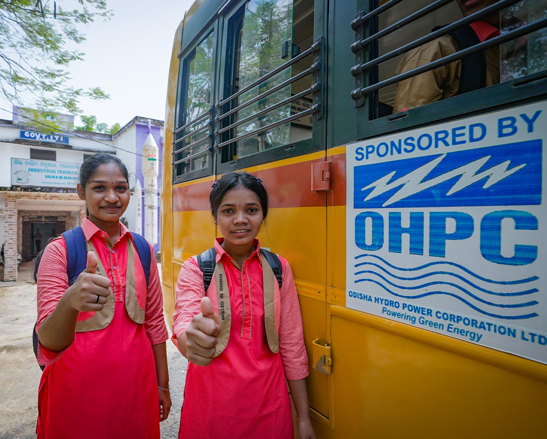 Schoolgirls beside OHPC-sponsored bus